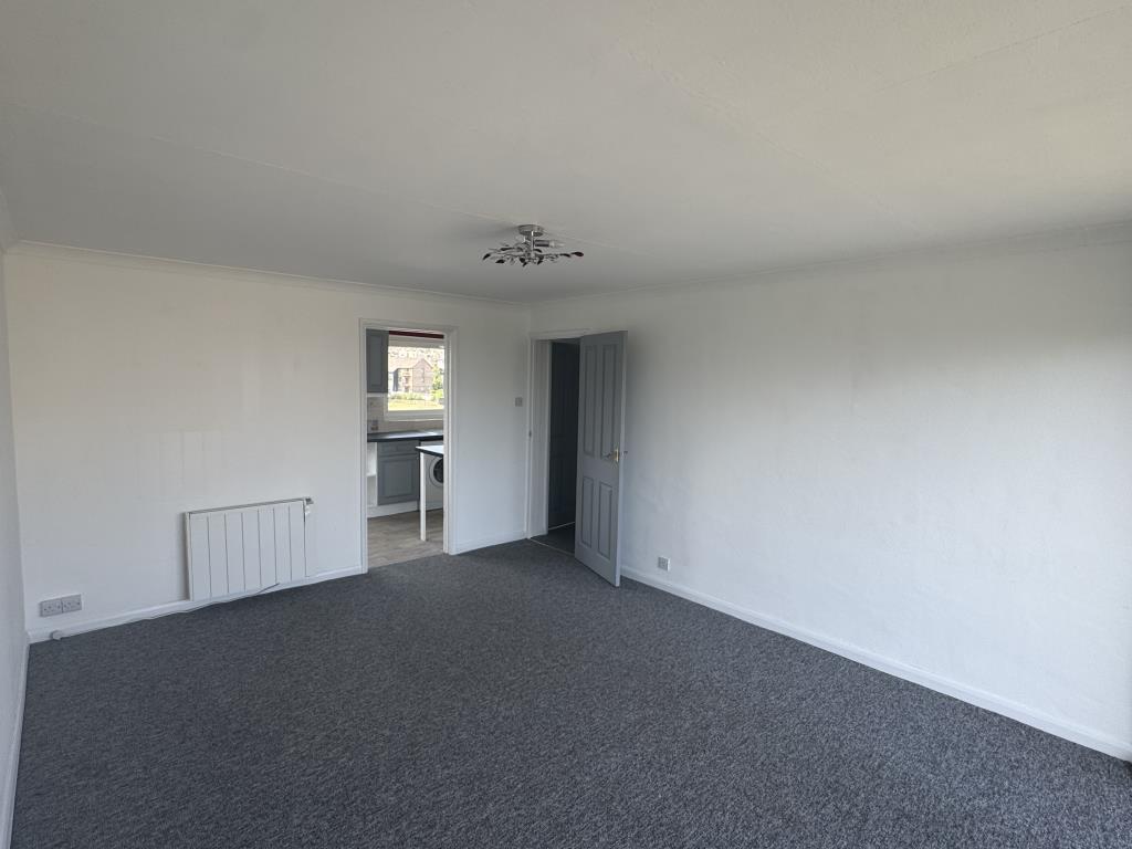 Lot: 168 - TWO-BEDROOM FLAT WITH GARAGE CLOSE TO THE SEAFRONT - Living room with grey carpet and white walls